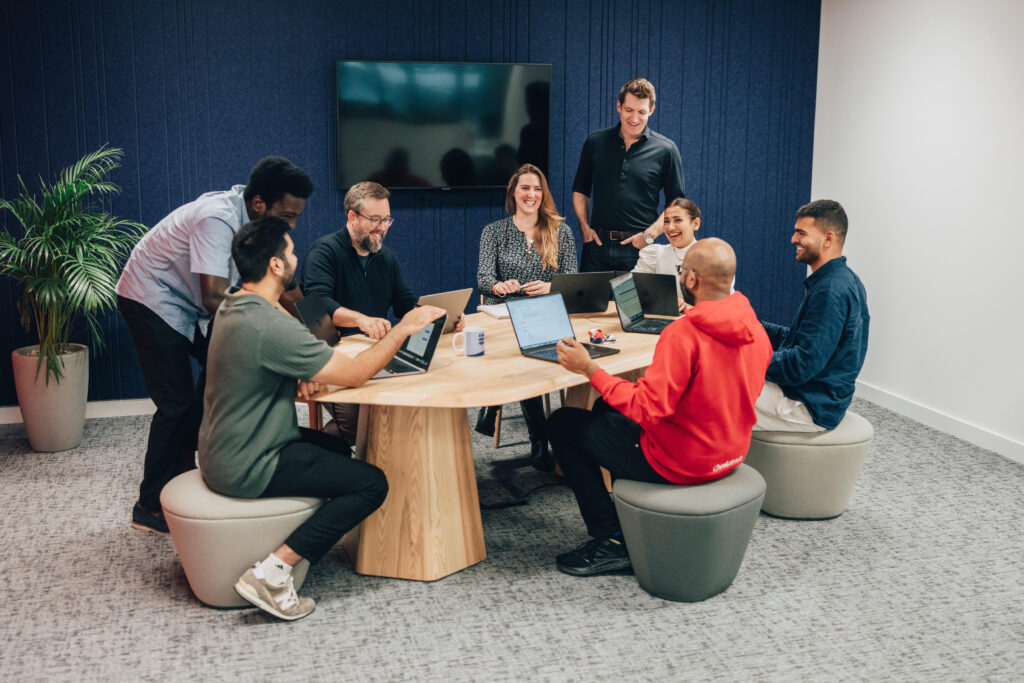 Checkatrade employees talking at table in office